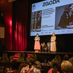 Prelegentka pokazu oraz Joanna Bojczuk Członek Zarządu Województwa stojące na scenie, w tle pokaz filmu